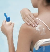 applying sunscreen to back shoulder
