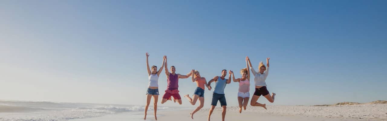 group jumping on beach in air