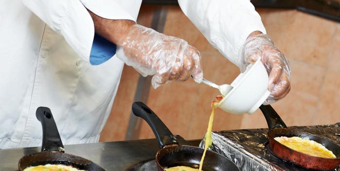 Chef preparing omelets per order at a cooking station.