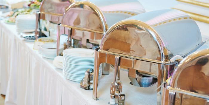Silver chafing dishes filled with delicious breakfast items. 