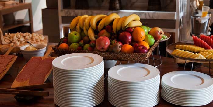 Fresh fruit and plates on a buffet table.