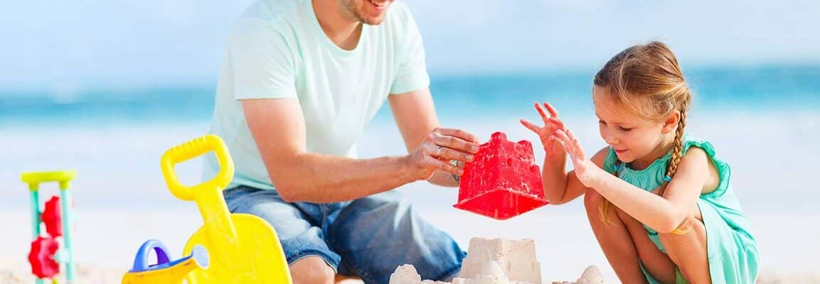 father and daughter making sand castle