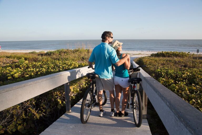 Couple on bikes looking at beach sundial sanibel bike rental