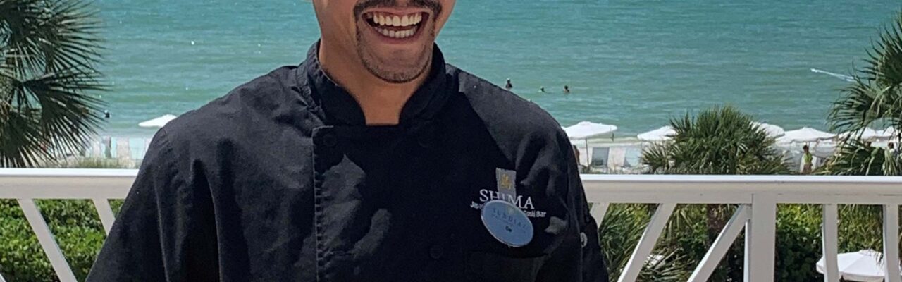 Chef Sai from Shima at the Sundial Resort holding sushi