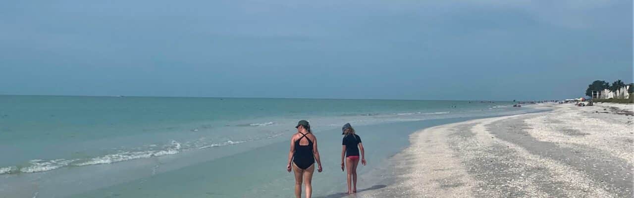 mother and daughter shelling on sanibel island walking on beach