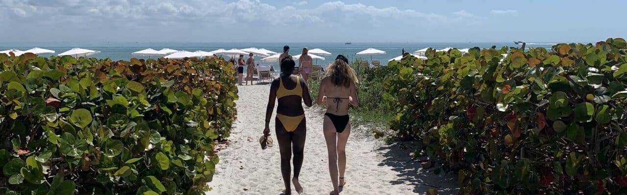 two girls walking on beach path toward gulf sanibel island