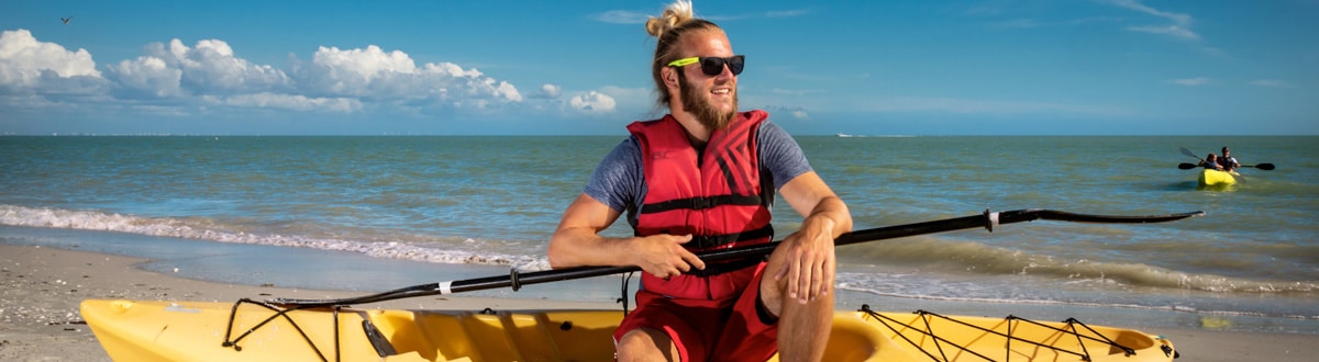 Sundial Kayaking man in boat on shore sanibel beach