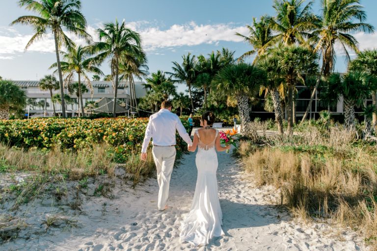 Brice & Stephanie’s Sundial Resort Beach Wedding sanibel bride groom walking up sand from behind