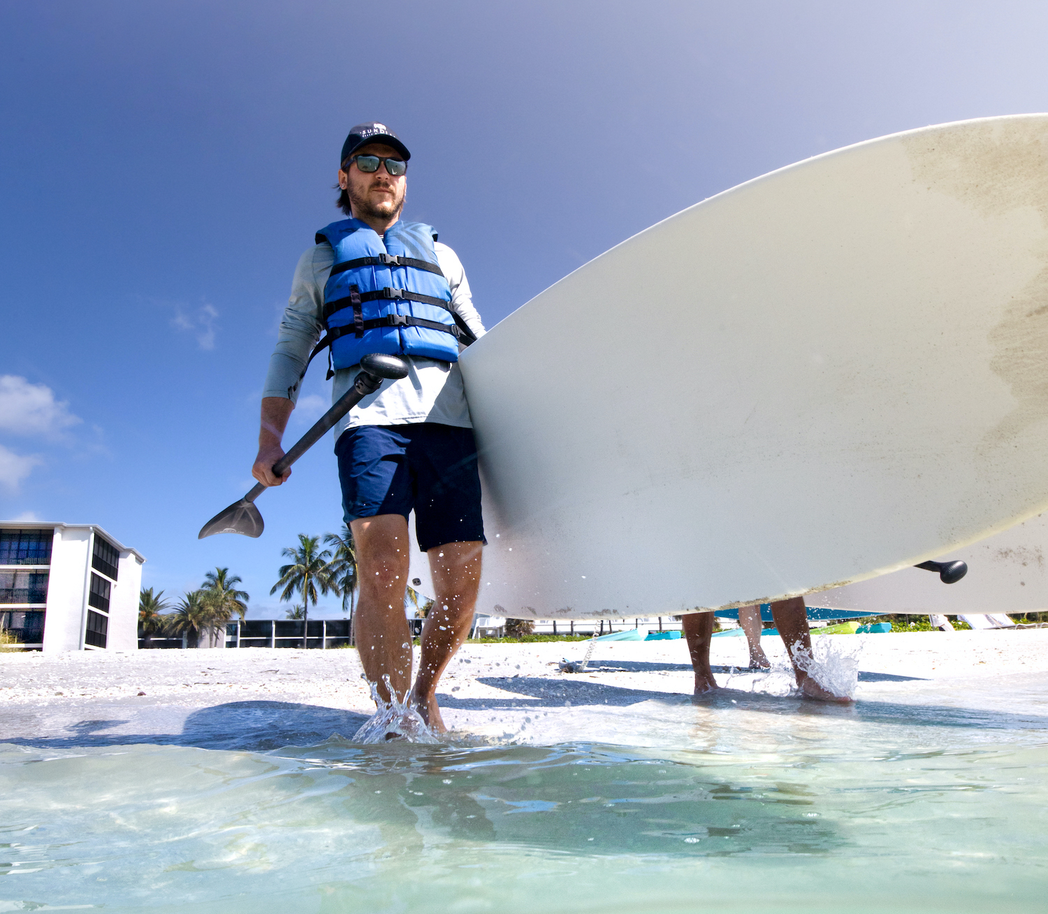 get active paddleboard walking into water sundial sanibel