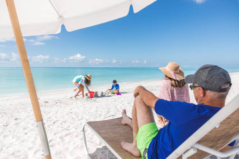 family on beach playing lounging by water sundial sanibel