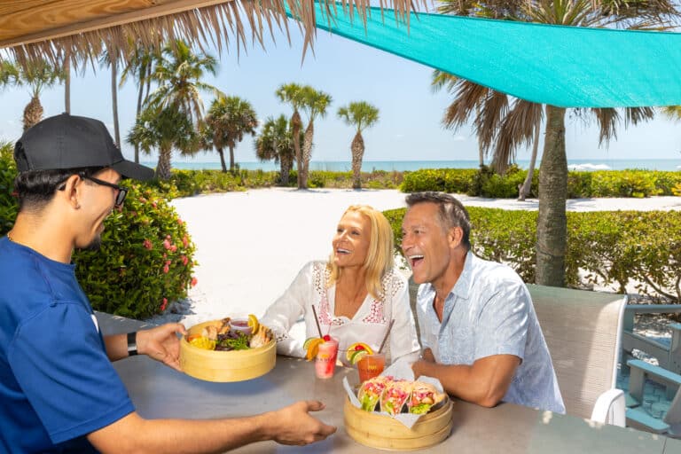 older couple seated at beach pool tiki bar sanibel sundial