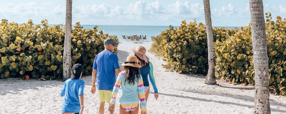 family walking beach path toward beach gulf sanibel island