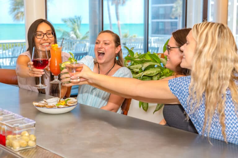 women toasting cheersing eachother at bar captain’s catch restaurant sundial resort sanibel