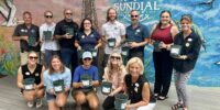 sundial staff members posing with mangrove seedlings for the SCCF mangrove restoration project