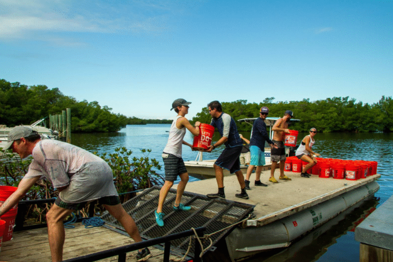 volunteers form a daisy chain to offload oyster shells for the SCCF oyster restoration project on sanibel and captiva islands