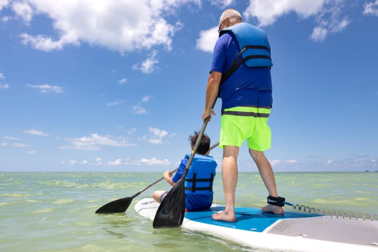 sundial resort father and son paddleboarding on the gulf