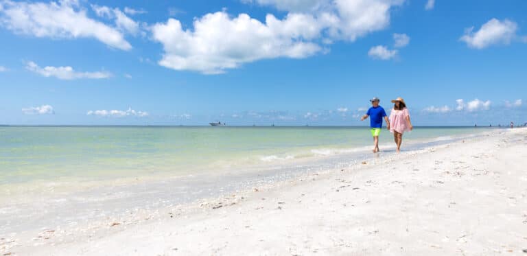 couple walking on sanibel beach gulf of mexico crop