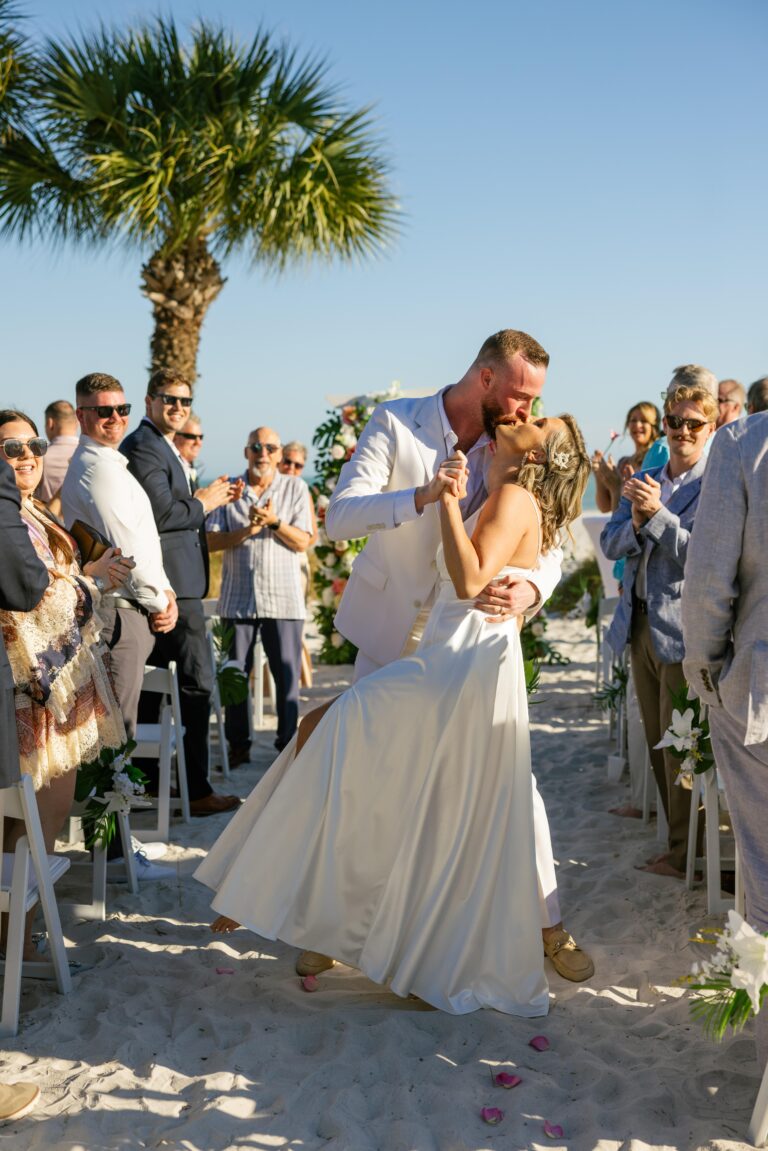 Austin and Kelsey’s wedding photo by Complete Wedding and Events Fort Myers wedding cermony after i do bride and groom kiss in aisle