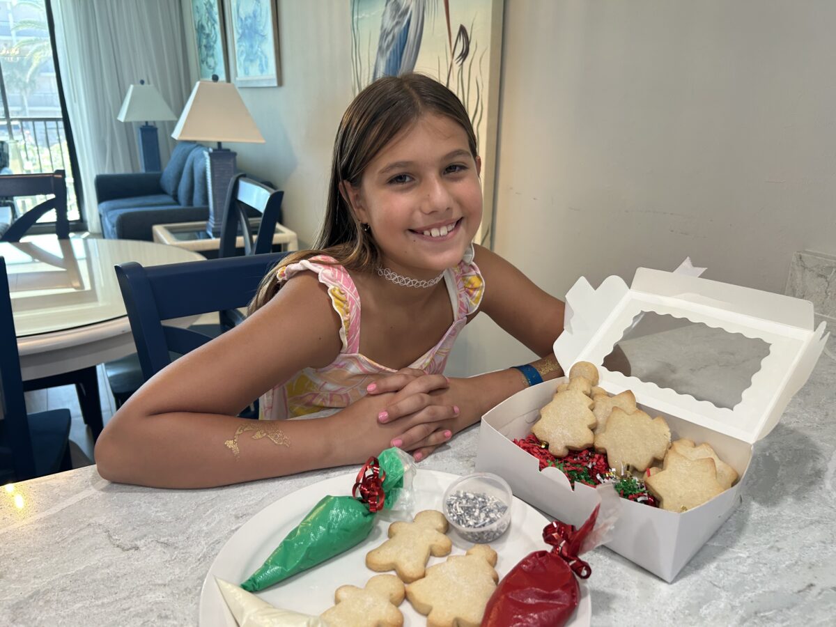 christmas holiday cookie decorating kit with young girl smiling with it