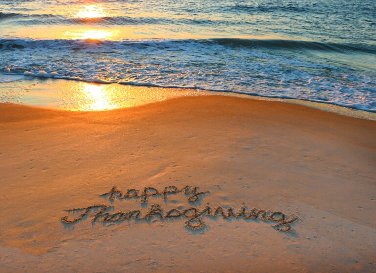 thanksgiving written in the sand on the beach