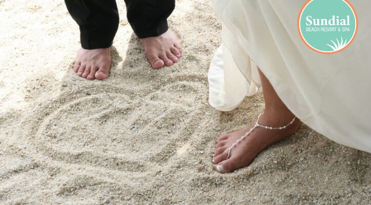 bride and groom feet beach heart in sand